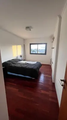 a bedroom with a bed and a wooden floor at Dto con pileta en Carlos Paz 28! in La Cuesta