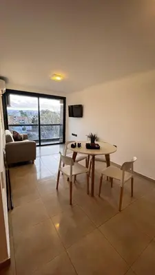 a living room with a table and chairs and a couch at Dto con pileta en Carlos Paz 28! in La Cuesta