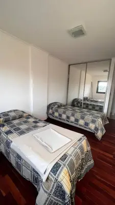 a hotel room with two beds and a mirror at Dto con pileta en Carlos Paz 28! in La Cuesta