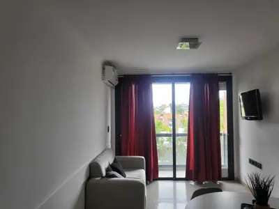 a living room with a couch and a large window at Dto con pileta en Carlos Paz 28! in La Cuesta