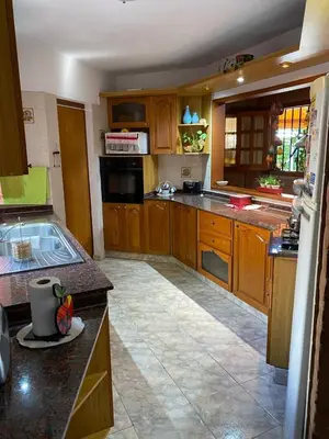 a kitchen with wooden cabinets and a counter top at Chalet Espectacular in Villa Carlos Paz
