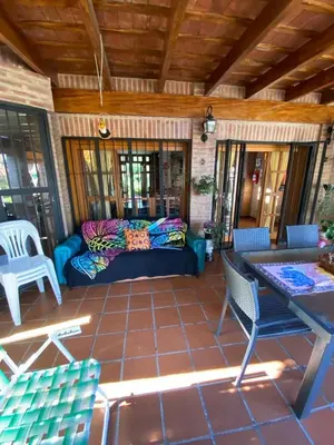 a patio with a couch and a table and chairs at Chalet Espectacular in Villa Carlos Paz