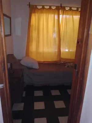 a bedroom with a bed and a yellow window at Los Nogales in Los Hornillos