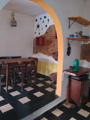 a dining room with a table and a room with a checkered floor at Los Nogales in Los Hornillos