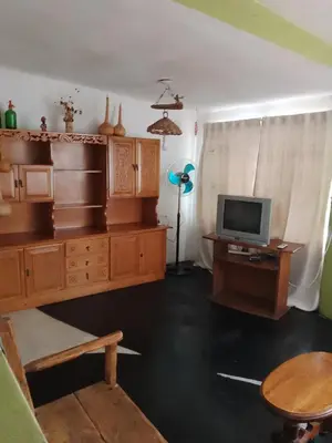 a living room with a tv and a desk with a computer at Los Nogales in Los Hornillos