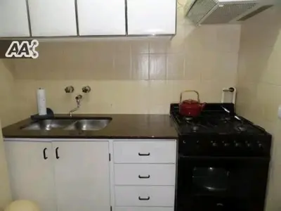 a kitchen with a black stove and a sink at Rincón del Descanso in San Antonio de Arredondo