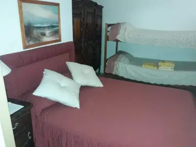 a bedroom with a red couch and a bunk bed at Rincón del Descanso in San Antonio de Arredondo