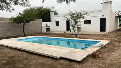 a swimming pool in front of a house at Cabañas Valle de Anisacate 4 in Villa Anizacate