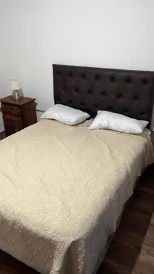 a bed with a black headboard and two white pillows at Cabañas Valle de Anisacate 4 in Villa Anizacate