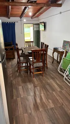 a dining room with a table and chairs and a refrigerator at Cabañas Valle de Anisacate 4 in Villa Anizacate