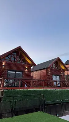 a wooden building with a bench in front of it at Vista Encantada Complejo in Villa Carlos Paz