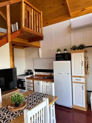 a kitchen with a white refrigerator and a table at Vista Encantada Complejo in Villa Carlos Paz