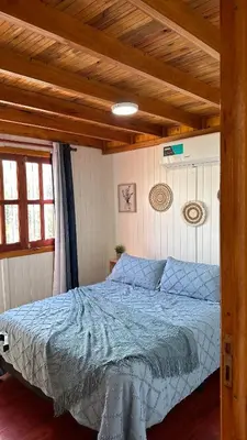 a bedroom with a bed with a blue comforter at Vista Encantada Complejo in Villa Carlos Paz