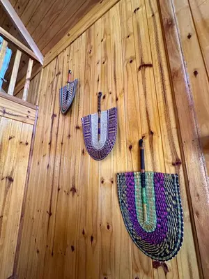 three umbrellas on the wall of a wooden wall at Vista Encantada Complejo in Villa Carlos Paz