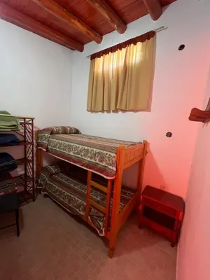 a room with two bunk beds and a window at Departamento en Complejo Panaholma in Villa Cura Brochero