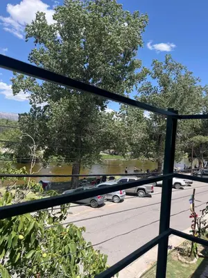 a view of a parking lot through a fence at Departamento en Complejo Panaholma in Villa Cura Brochero