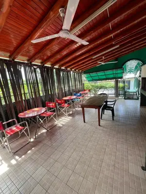 a patio with tables and chairs and a ceiling fan at Departamento en Complejo Panaholma in Villa Cura Brochero