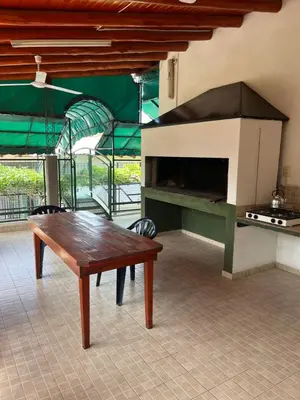 a kitchen with a table and a large oven at Departamento en Complejo Panaholma in Villa Cura Brochero