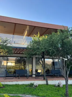 a building with benches and trees in front of it at Bellamontagna Suites in Mina Clavero
