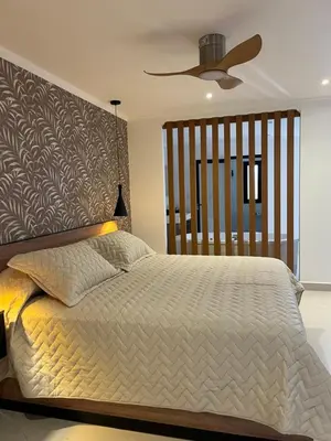 a bedroom with a large bed with a ceiling fan at Bellamontagna Suites in Mina Clavero