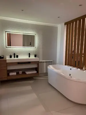 a bathroom with a tub and a sink and a mirror at Bellamontagna Suites in Mina Clavero
