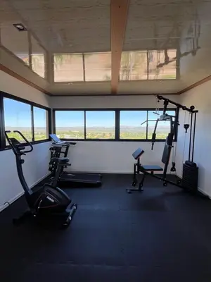 a gym with two exercise bikes in a room with windows at Bellamontagna Suites in Mina Clavero