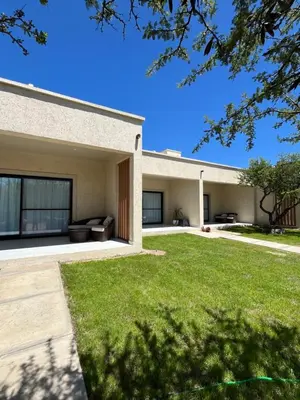 a house with a green lawn in front of it at Bellamontagna Suites in Mina Clavero