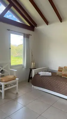 a bedroom with a large bed and a window at Cabaña Aguaribay in Mina Clavero
