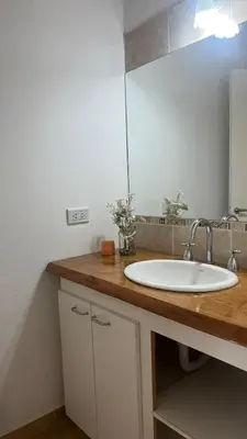 a bathroom counter with a sink and a mirror at Cabaña Aguaribay in Mina Clavero