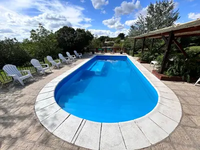 a swimming pool with lounge chairs around it at Cabaña Aguaribay in Mina Clavero