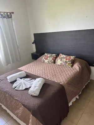 a bedroom with a bed with two towels on it at Cabaña Aguaribay in Mina Clavero