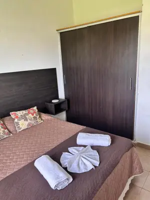 a bedroom with a bed with towels on it at Cabaña Aguaribay in Mina Clavero