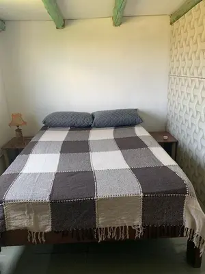 a bed with two pillows on it in a room at La Roca in Estancia Vieja