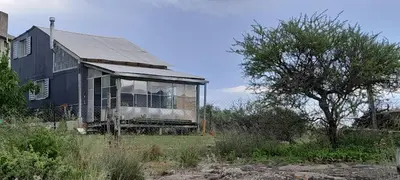 an old house sitting in the middle of a field at La Roca in Estancia Vieja