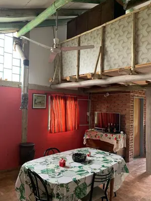 a dining room with a table and a red wall at La Roca in Estancia Vieja