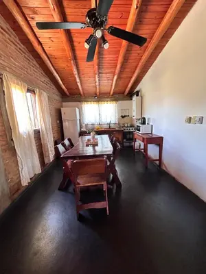 a dining room with a ceiling fan and a table at Cabaña Alamo in Mina Clavero