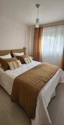 a bedroom with a large bed with a brown blanket at Gama Villasol Temporario in Cordoba