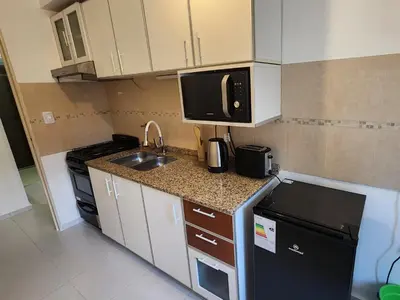 a small kitchen with a sink and a microwave at Gama Villasol Temporario in Cordoba