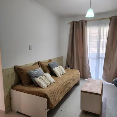 a bedroom with a couch with pillows on it at Gama Villasol Temporario in Cordoba