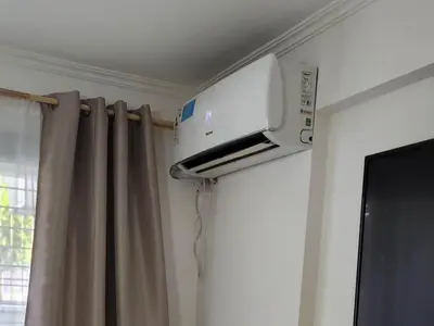 a television on a wall in a room with curtains at Gama Villasol Temporario in Cordoba