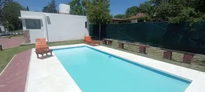 a swimming pool with a chair and a fence at Nuevos Aires de San Antonio in San Antonio de Arredondo
