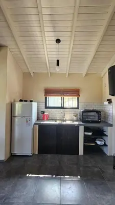 a kitchen with a refrigerator and a sink at Los Chivos in Villa Cura Brochero