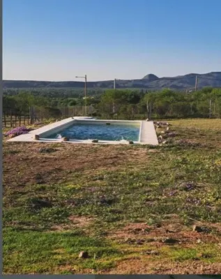 a swimming pool in the middle of a field at Los Chivos in Villa Cura Brochero