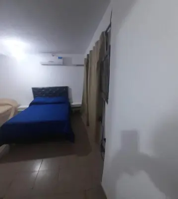 a small bedroom with a blue bed and a tv at Cabañas cochico in Villa Carlos Paz