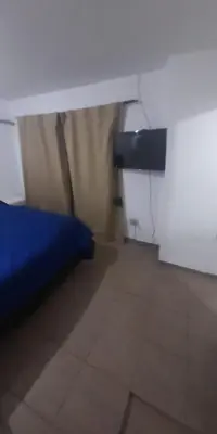 a bedroom with a bed and a tv in a room at Cabañas cochico in Villa Carlos Paz