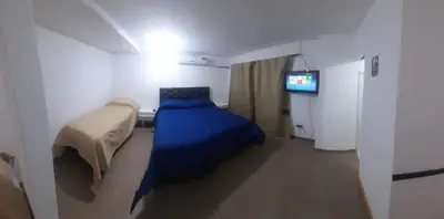 a small room with a bed and a television at Cabañas cochico in Villa Carlos Paz