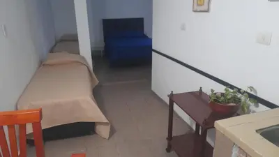 a small room with a bed and a stair case at Cabañas cochico in Villa Carlos Paz