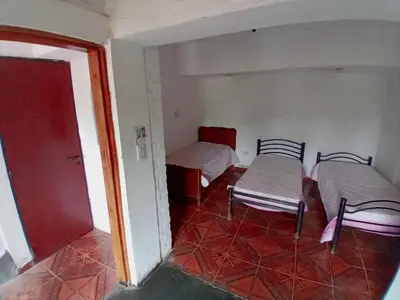 a room with two beds and a table and chairs at Casa en Rumipal de 4 a 11 personas in Villa Rumipal