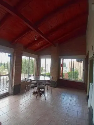 a dining room with a table and chairs and windows at Casa en Rumipal de 4 a 11 personas in Villa Rumipal