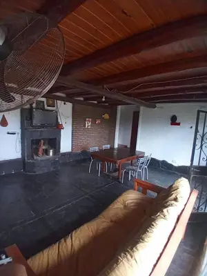a living room with a couch and a table and a fireplace at Casa en Rumipal de 4 a 11 personas in Villa Rumipal